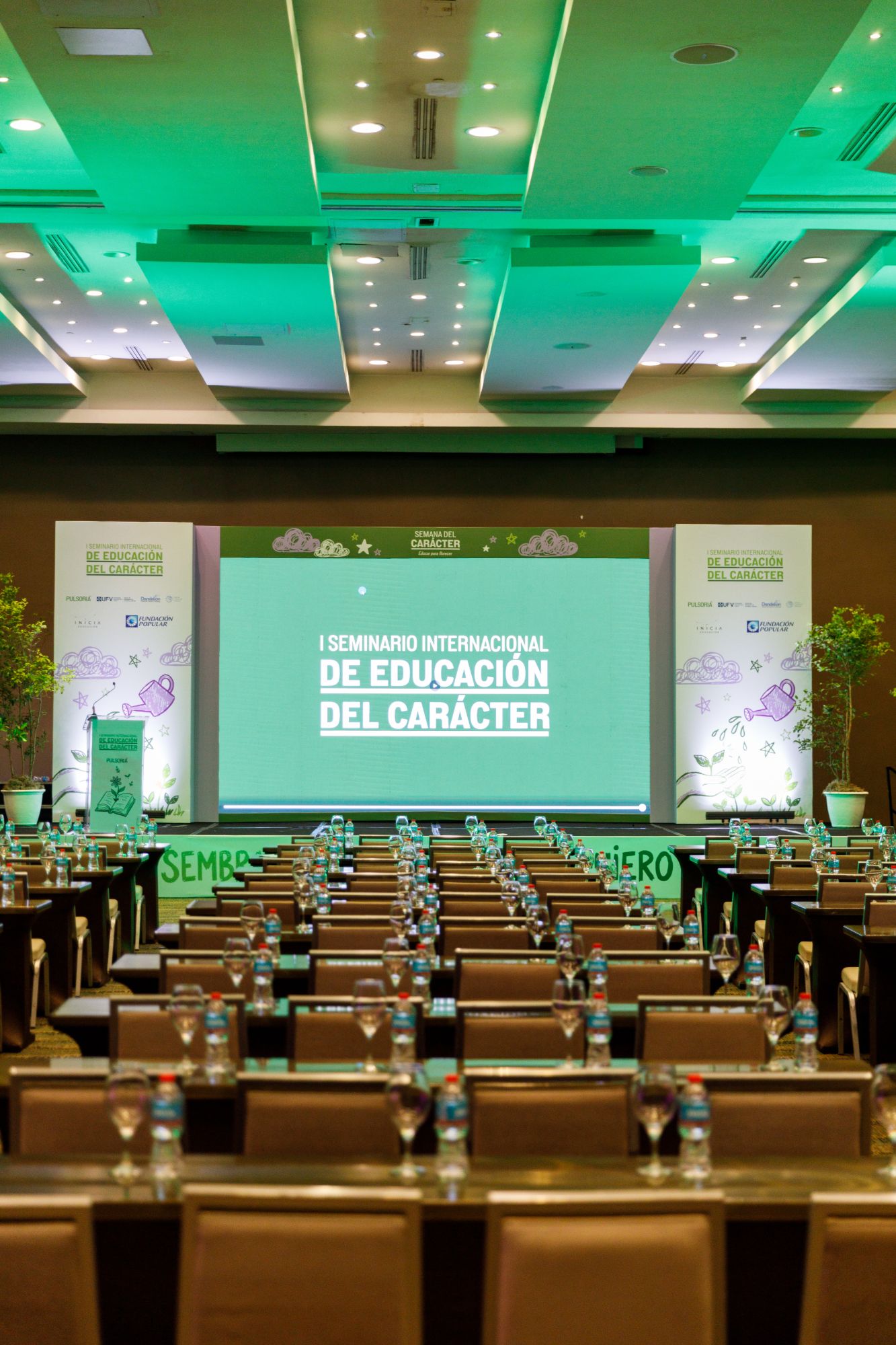 Salón del I Seminario Internacional de Educación del Carácter, con el escenario y la pantalla en verde