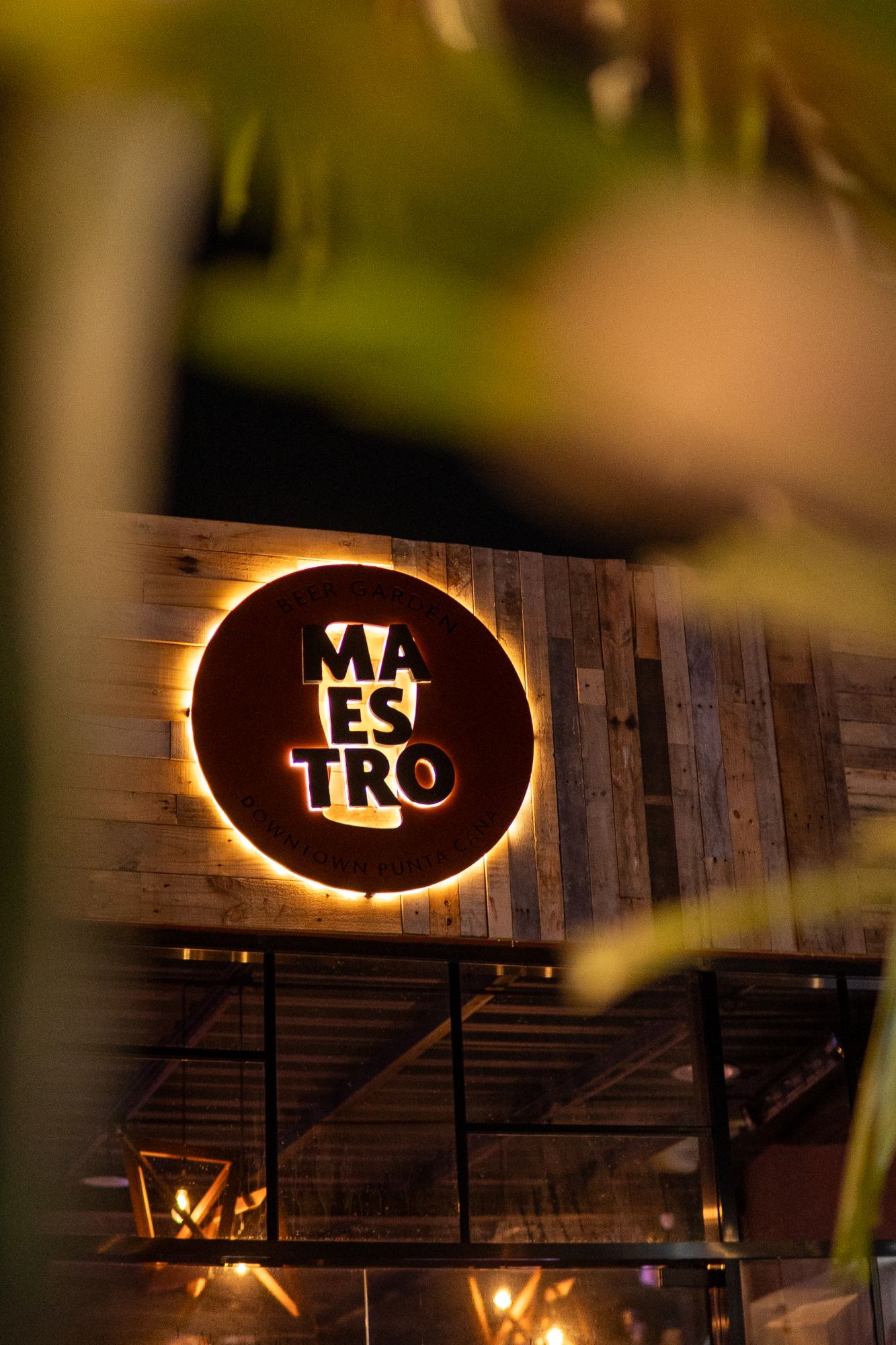 Letrero iluminado de Maestro Beer Garden sobre una pared de madera